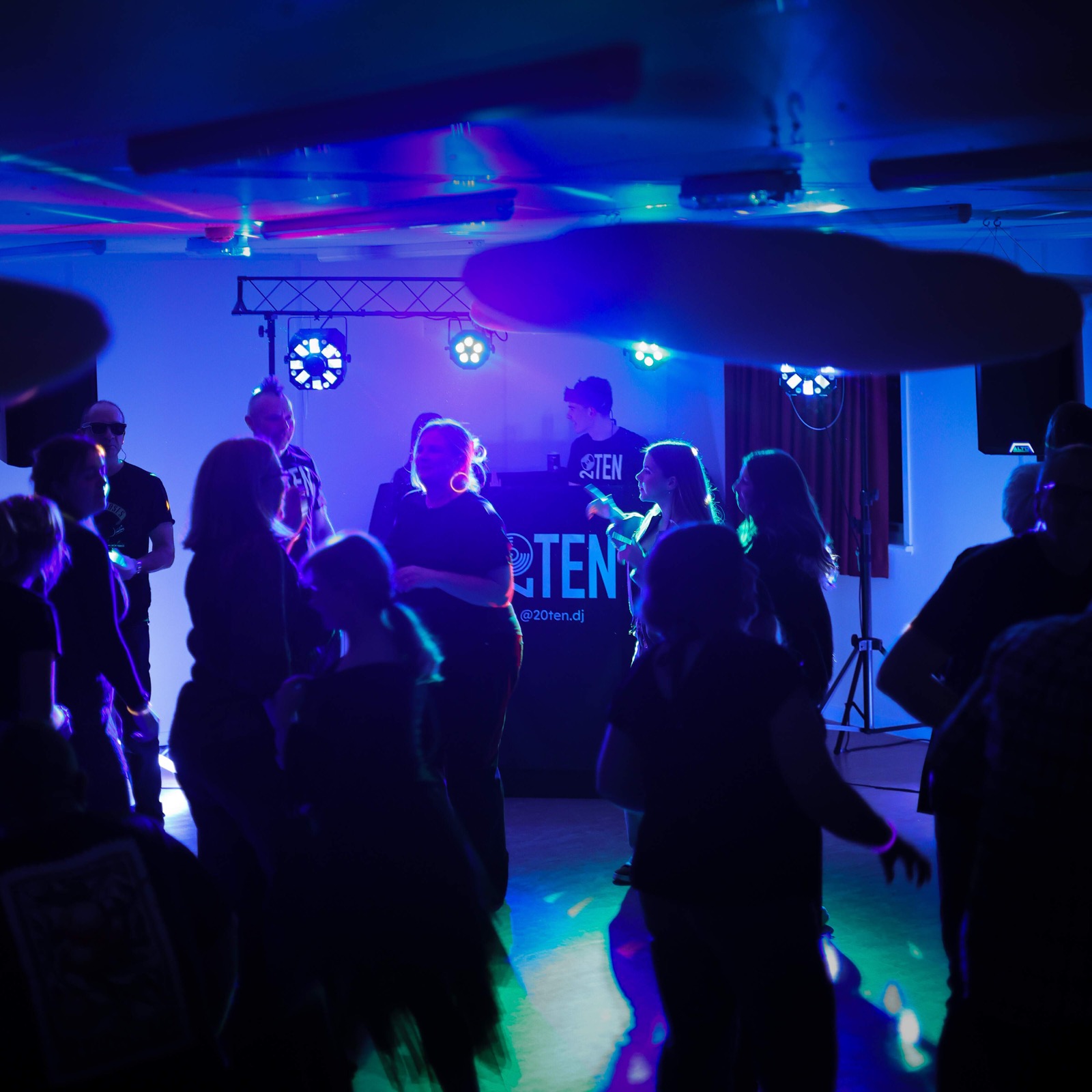 High-impact moving heads light show on a packed dance floor