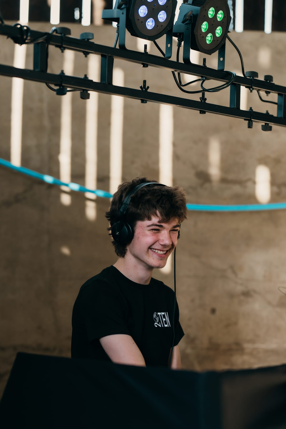Charlie smiling behind the decks in headphones