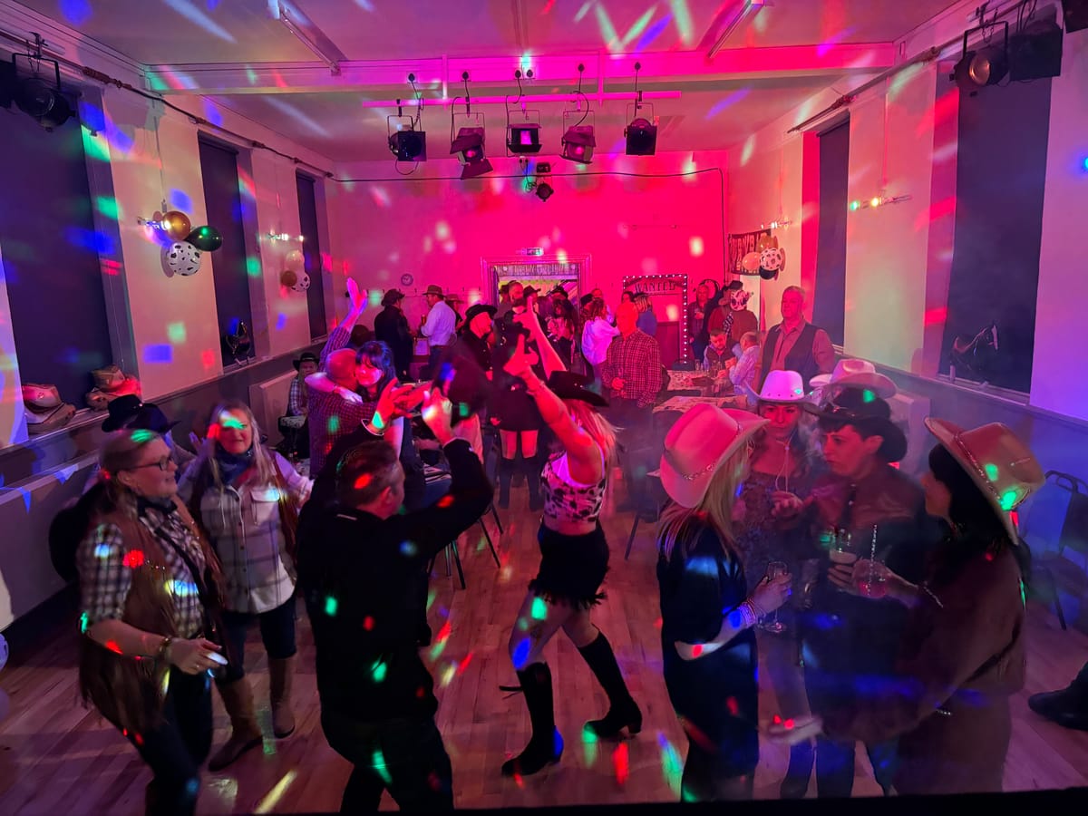 Guests dancing under purple lights at a party